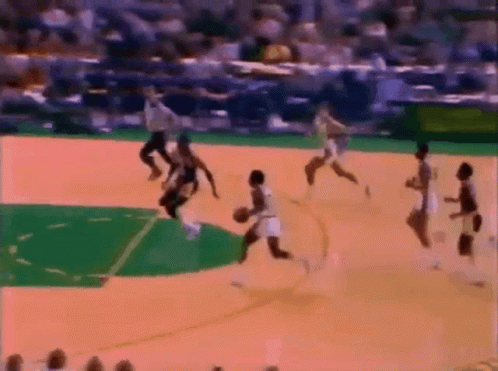 A Group Of People Are Playing Basketball On A Court With A Referee In The Background GIF
