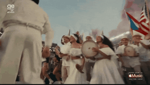 A Group Of People Are Playing Drums In Front Of A Sign That Says Music GIF
