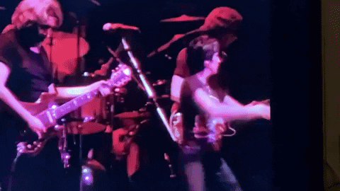A Group Of People Are Playing Guitars And Singing On Stage . GIF