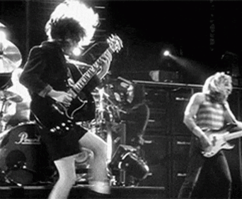 A Group Of People Are Playing Guitars On A Stage . GIF