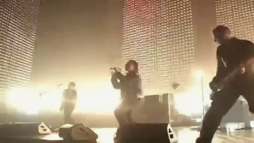 a group of people are playing instruments on a stage in front of a wall .