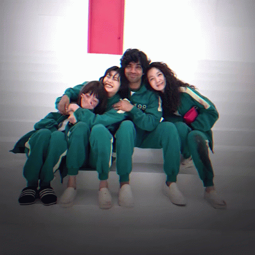 A Group Of People Are Posing For A Picture And One Of Them Has The Number 99 On Their Outfit GIF