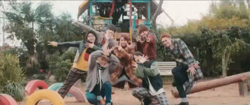 A Group Of People Are Posing For A Picture In A Playground . GIF