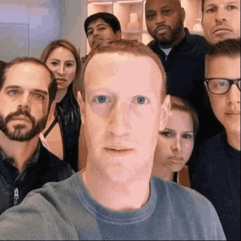 A Group Of People Are Posing For A Picture With A Man In The Middle Making A Face . GIF