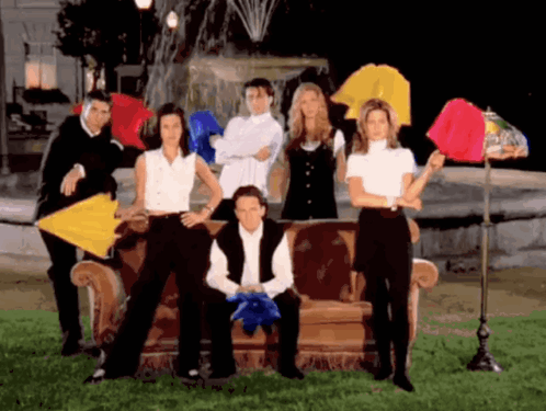 A Group Of People Are Posing For A Picture With Umbrellas In Front Of A Fountain GIF