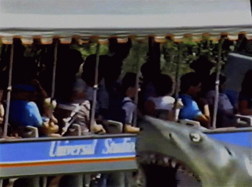 A Group Of People Are Riding A Trolley That Says Universal Studios GIF