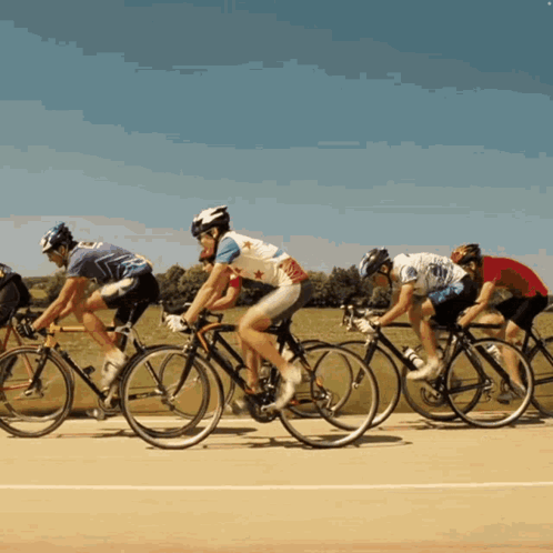 A Group Of People Are Riding Bikes On A Track GIF