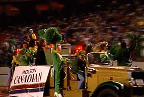 A Group Of People Are Riding In A Car With A Sign That Says Canadian On It . GIF