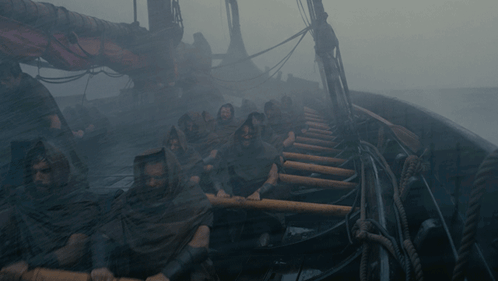 A Group Of People Are Rowing A Boat In The Water GIF