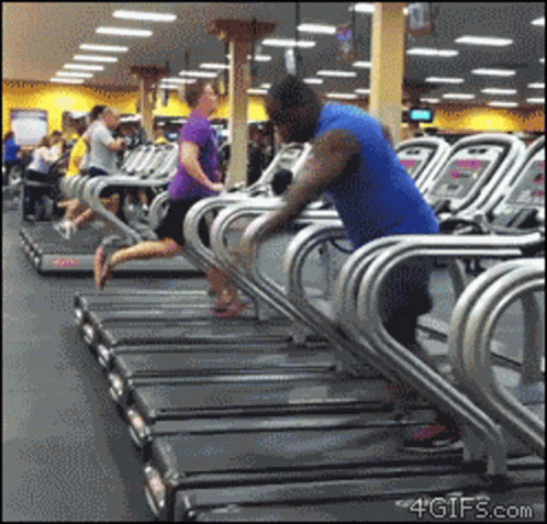 A Group Of People Are Running On Treadmills In A Gym GIF