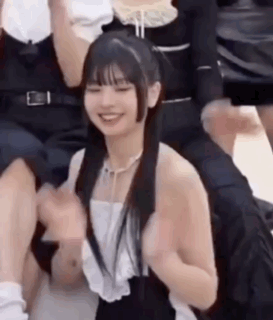 A Group Of People Are Sitting Around A Girl . GIF