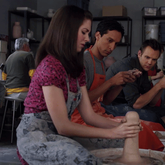 A Group Of People Are Sitting Around A Pottery Wheel Making Clay Sculptures GIF