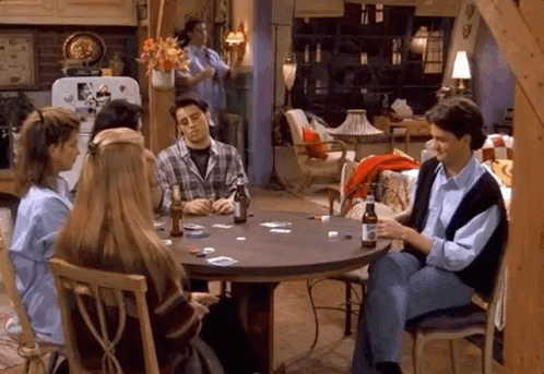 A Group Of People Are Sitting Around A Table Playing Cards With Bottles Of Beer . GIF