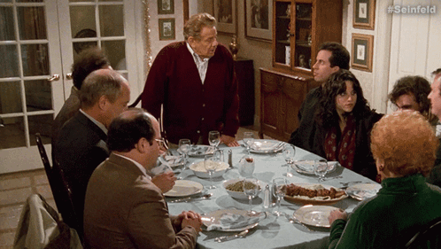 A Group Of People Are Sitting Around A Table With #Seinfeld Written On The Bottom Right GIF
