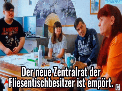 People Sitting Around Table With Caption GIF