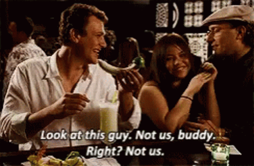 A Group Of People Are Sitting At A Table And One Of Them Is Saying Look At This Guy Not Us Buddy Right Not Us . GIF