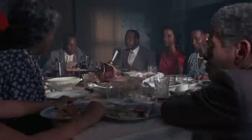 a group of people are sitting at a table eating food .