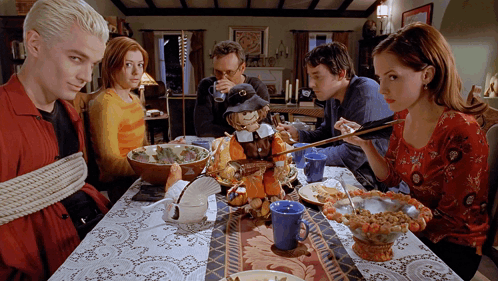 People Sitting At Table With Stuffed Pilgrim GIF