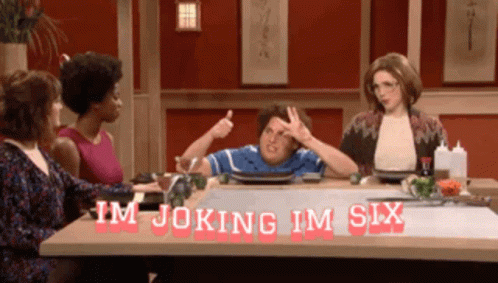 A Group Of People Are Sitting At A Table With The Words Im Joking Im Six Written On It GIF
