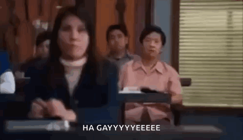 A Group Of People Are Sitting At Desks In A Classroom . GIF