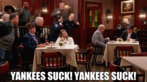 A Group Of People Are Sitting At Tables In A Restaurant With The Words Yankees Suck Yankees Suck Written On The Bottom GIF