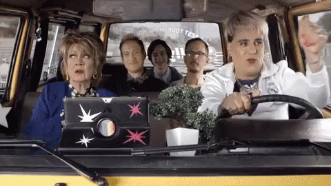 A Group Of People Are Sitting In A Car And One Of Them Has A Laptop On The Back Seat GIF