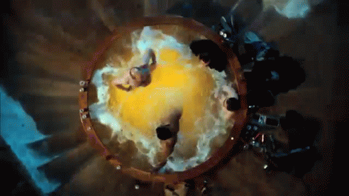 A Group Of People Are Sitting In A Circle With A Yellow Object In The Middle GIF