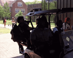 A Group Of People Are Sitting In A Golf Cart Numbered 31 GIF