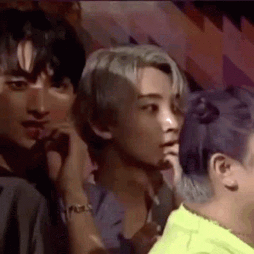 A Group Of People Are Sitting In A Room Talking To Each Other . One Of The People Has Purple Hair . GIF