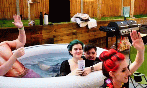 A Group Of People Are Sitting In An Inflatable Tub GIF