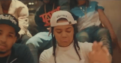 A Group Of People Are Sitting Next To Each Other In A Room . GIF