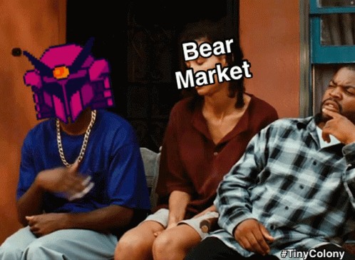 A Group Of People Are Sitting On A Bench And One Of Them Is Wearing A Bear Market Helmet GIF