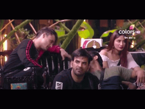 A Group Of People Are Sitting On A Bench With A Sign That Says Colors Hd On It GIF