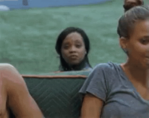 A Group Of People Are Sitting On A Couch And One Woman Is Looking At The Camera . GIF