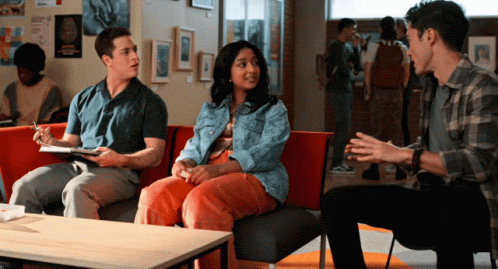 A Group Of People Are Sitting On A Couch In A Hallway GIF