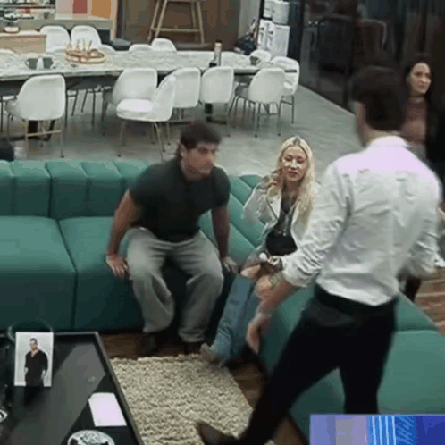 a group of people are sitting on a green couch