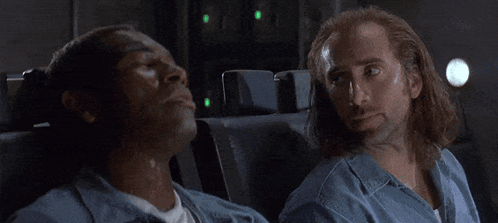 A Group Of People Are Sitting On A Plane And One Of Them Is Wearing A White Shirt GIF