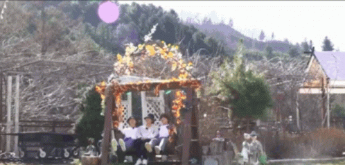 People Sitting On Wooden Swing In Park GIF
