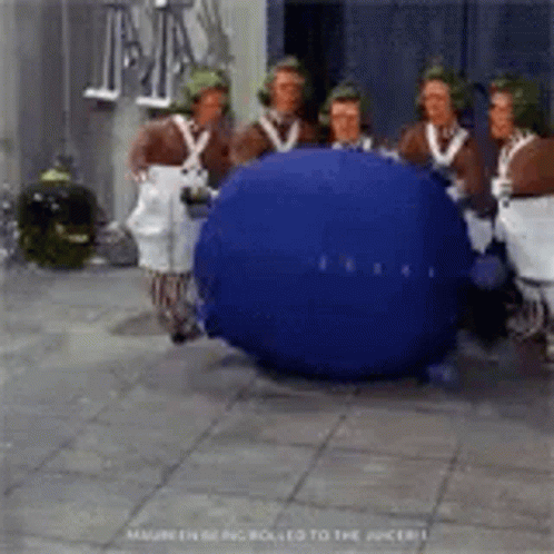 A Group Of People Are Standing Around A Blueberry . GIF
