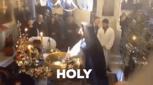 A Group Of People Are Standing Around A Coffin In A Church With The Word Holy Written On The Bottom . GIF