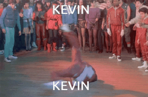 A Group Of People Are Standing Around A Man Doing A Trick With The Name Kevin Written Above Him GIF