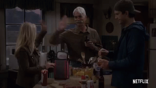 A Group Of People Are Standing Around A Table In A Kitchen With A Netflix Logo In The Corner . GIF