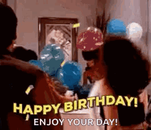 A Group Of People Are Standing Around A Table With Balloons And Saying `` Happy Birthday ! Enjoy Your Day ! `` GIF
