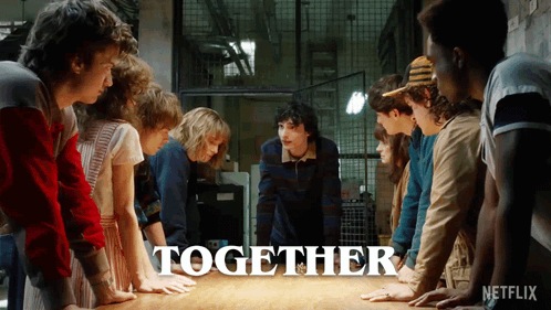 A Group Of People Are Standing Around A Table With The Word Together Written On It GIF
