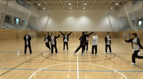 A Group Of People Are Standing In A Circle On A Court GIF