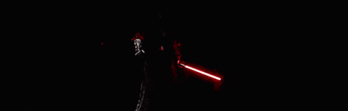 A Group Of People Are Standing In A Dark Room Holding Red Lightsabers . GIF