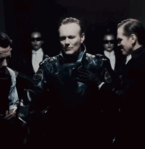 A Group Of People Are Standing In A Dark Room With A Sign On The Wall That Says Emergency GIF