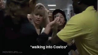 A Group Of People Are Standing In A Hallway Talking To Each Other . GIF