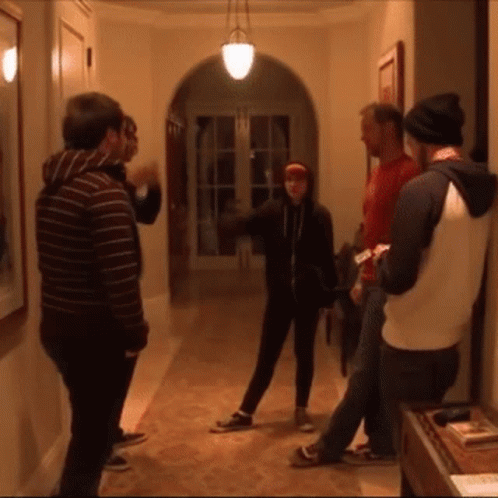 A Group Of People Are Standing In A Hallway GIF