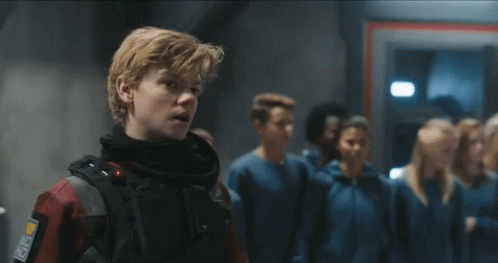 A Group Of People Are Standing In A Line In A Room . GIF